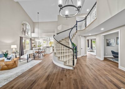 luxury living room with curved staircase, hardwood floors